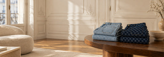 Jeans monogrammés MAX&MOI pliés sur une table. Collection Hiver 26