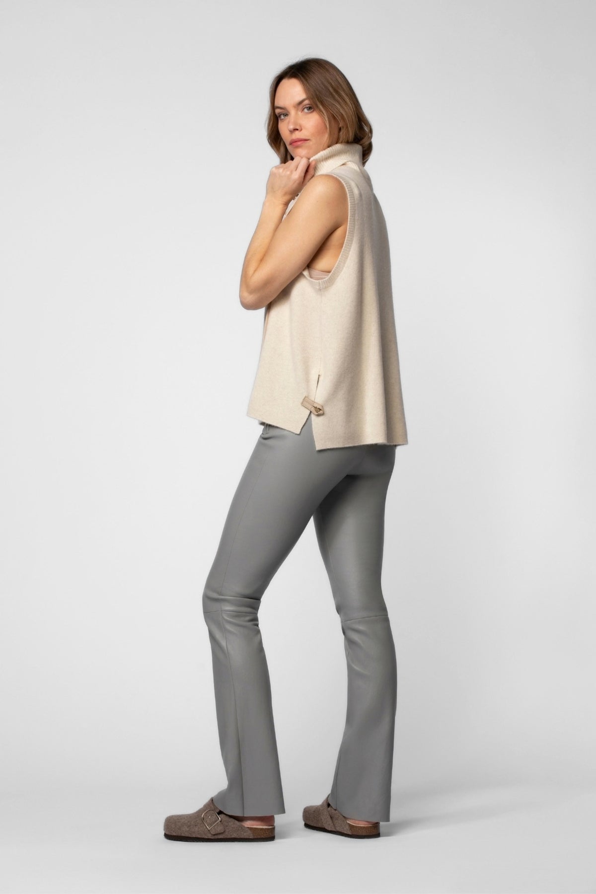 Femme portant un legging cuir flare évasé de couleur gris avec un pull cachemire des collections MAX&MOI