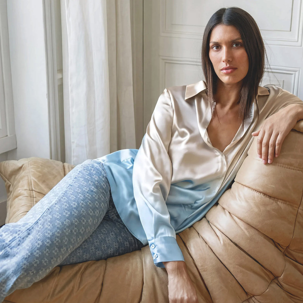 Femme portant le nouveau jean signature de la maison BELLE et la chemise en soie LEVY. Le jean BELLE est un modèle à coupe flare au monogramme MAX&MOI brodé all-over – Collection Automne-Hiver 2026